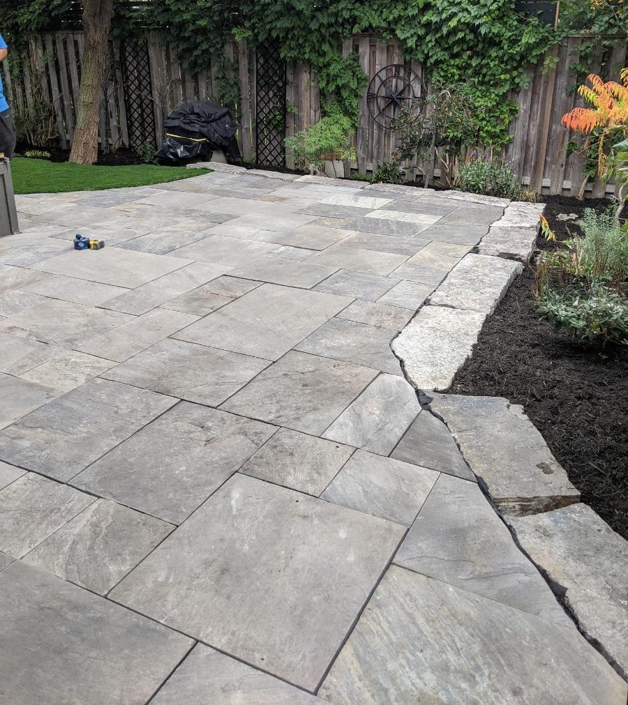 Grey paver patio with finger-rock border — Lakefield